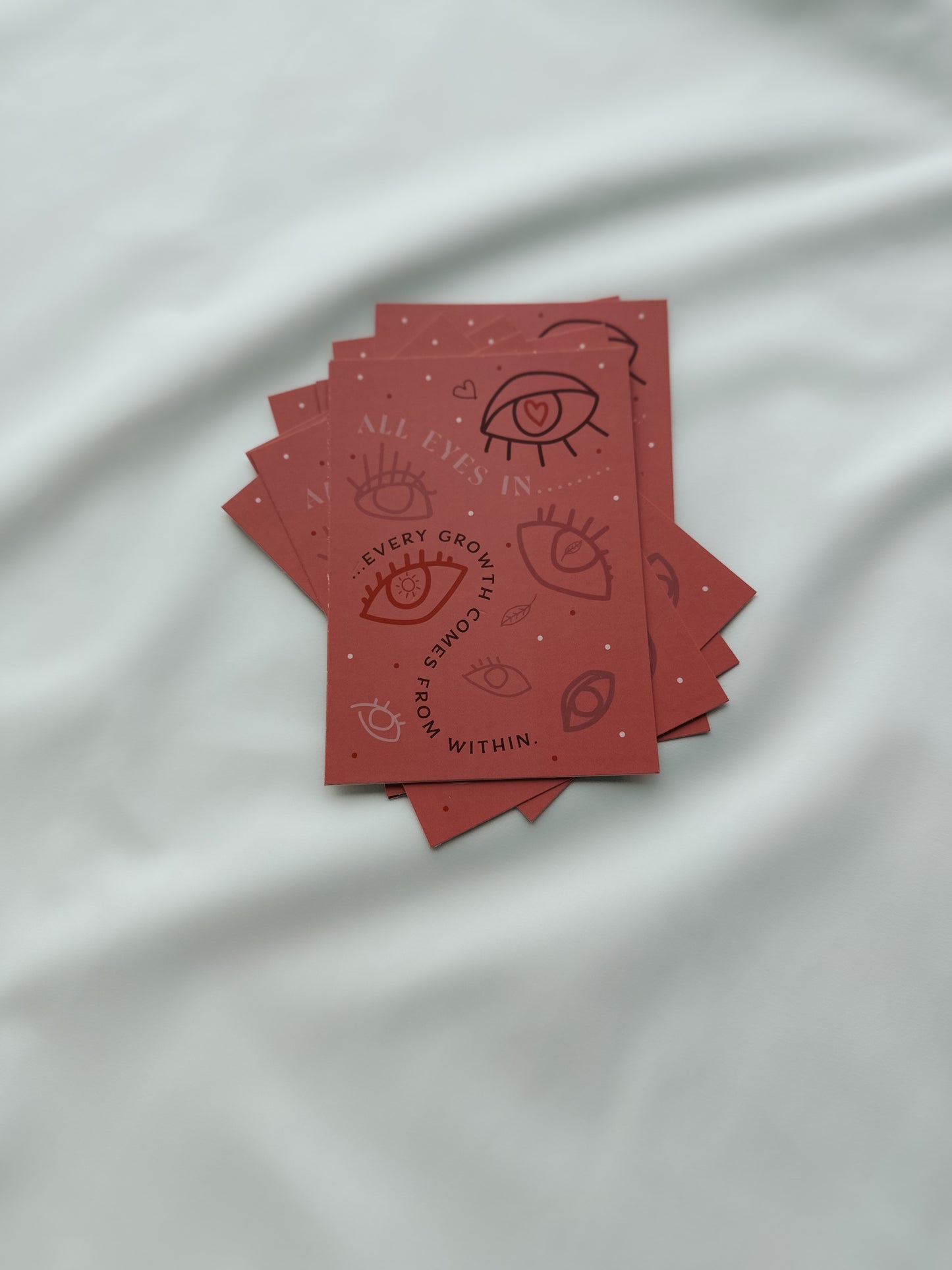 Ein Stapel Postkarten mit Augen und "Every growth comes from within" Aufdruck