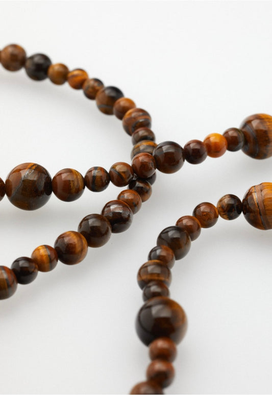 Nahaufnahme einer Brillenkette bestehend aus Tigeraugen Perlen in unterschiedlichen Größen
