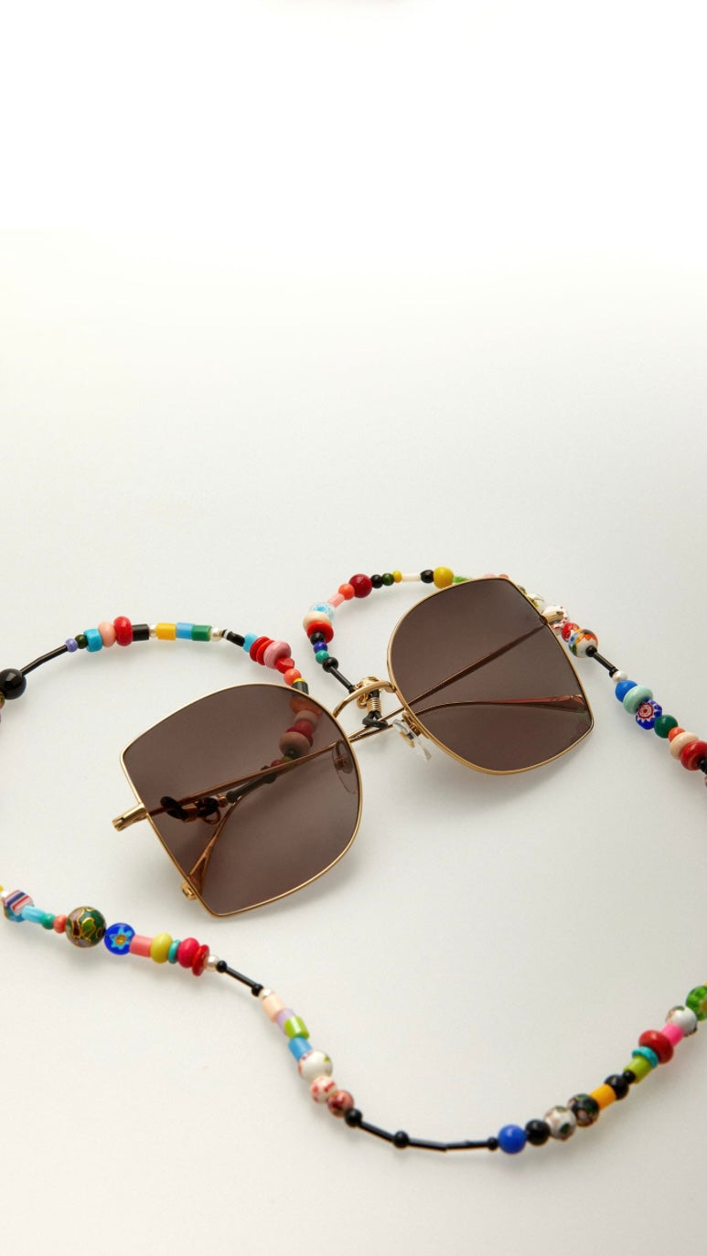 goldene Brille mit einer Brillenkette aus bunten Perlen