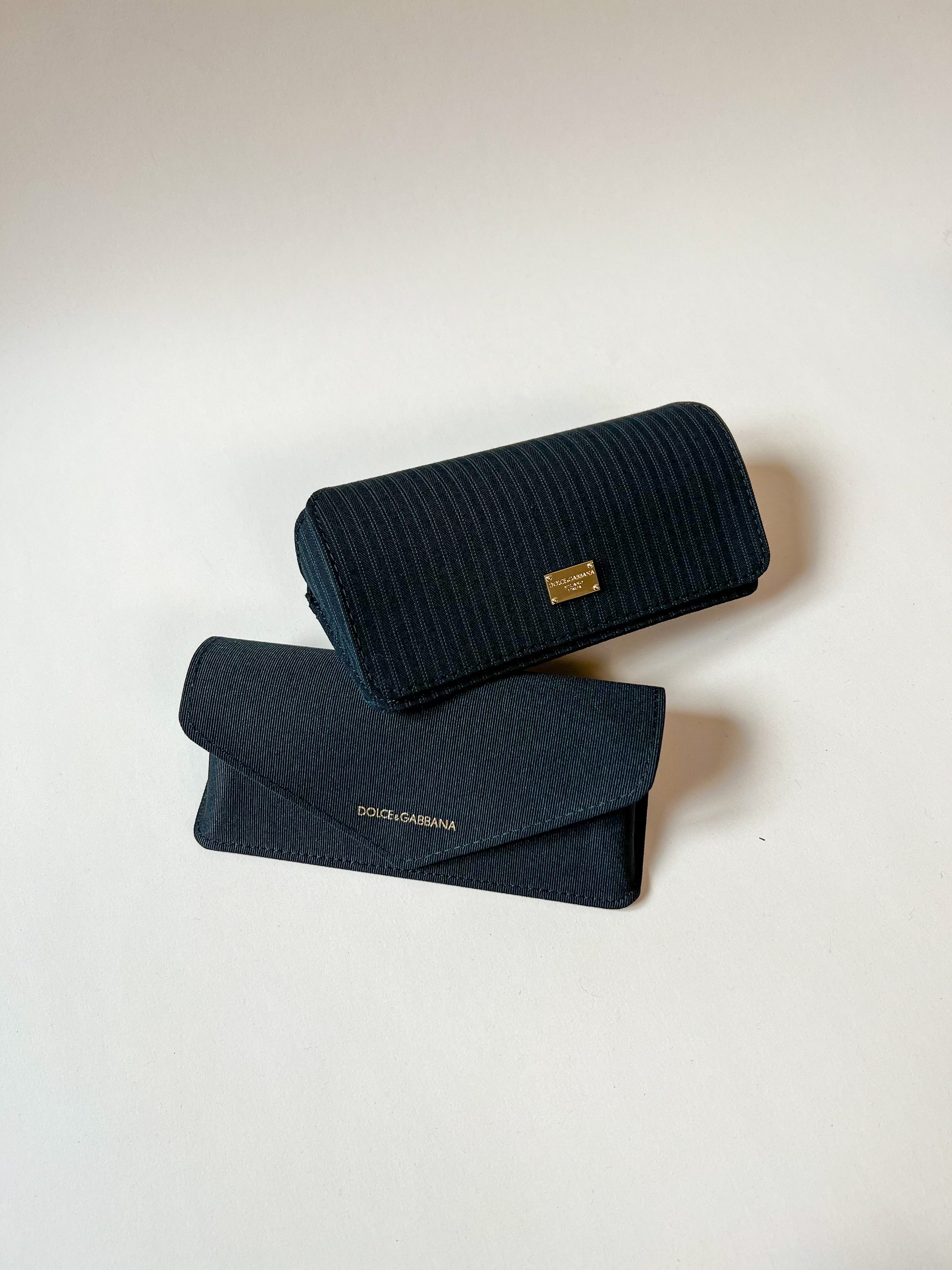 Zwei schwarze Dolce & Gabbana Etuis in verschiedenen Musterungen