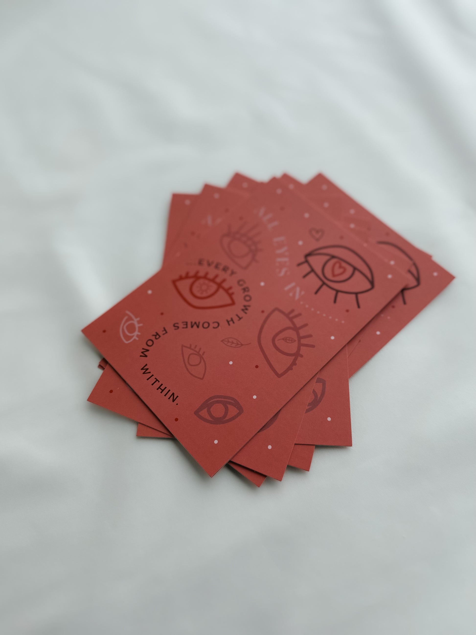 Ein Stapel Postkarten mit Augen und "Every growth comes from within" Aufdruck