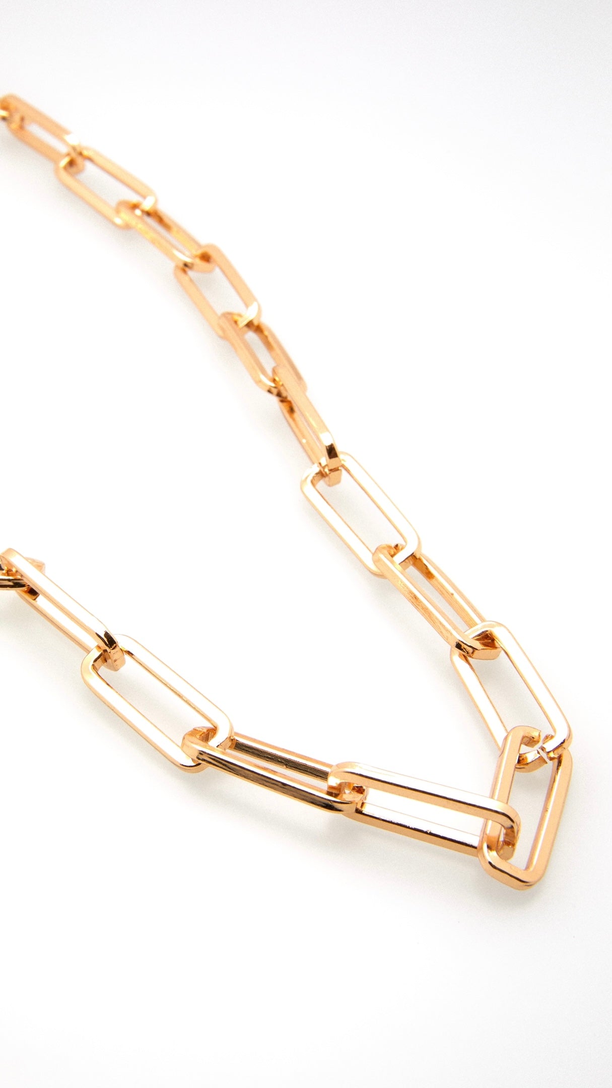 Nahaufnahme einer Brillenkette aus goldenen, eckigen, großen Kettengliedern