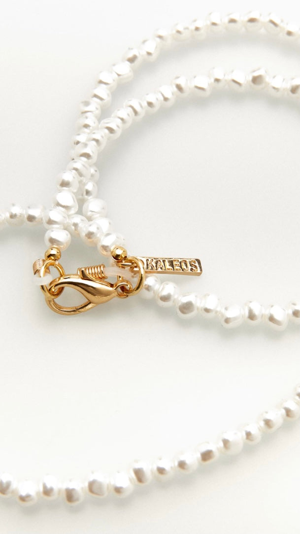 Nahaufnahme einer Brillenkette aus perlmuttfarbenen Perlen mit goldenem Verschluss 