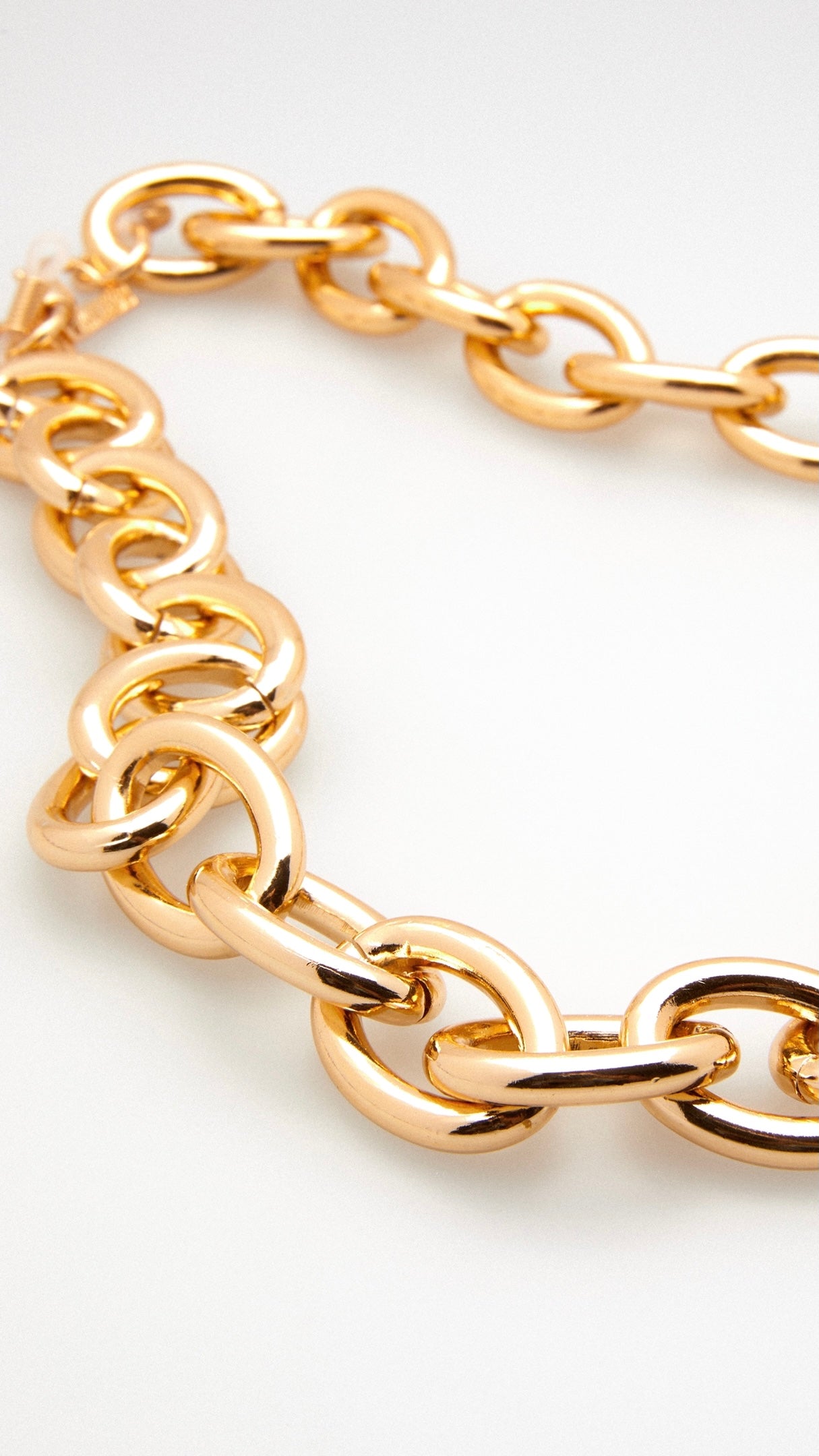 Nahaufnahme einer Brillenkette aus goldenen, runden, großen Kettengliedern
